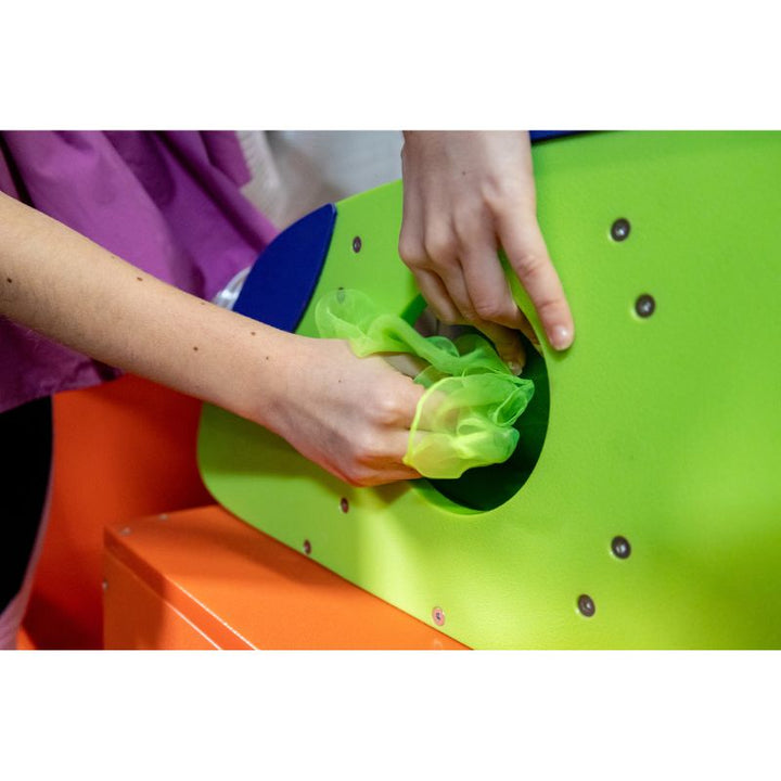 Child inserting a scarf into the LiteZilla Ultimate Scarf Launcher inlet to demonstrate air-powered pneumatic tube sensory play