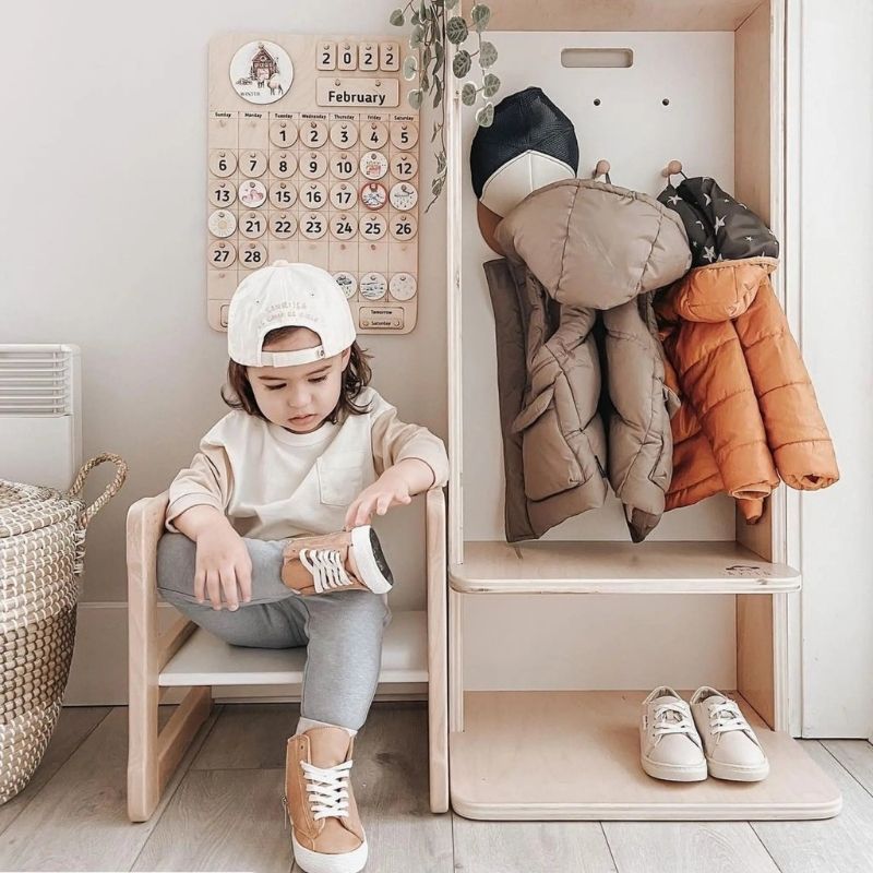 Sapiens Child Mango Montessori Cubby Coat Rack landscape view with child actively using the coat hooks, showing the entryway independence routine the Vancouver-made Montessori cubby supports