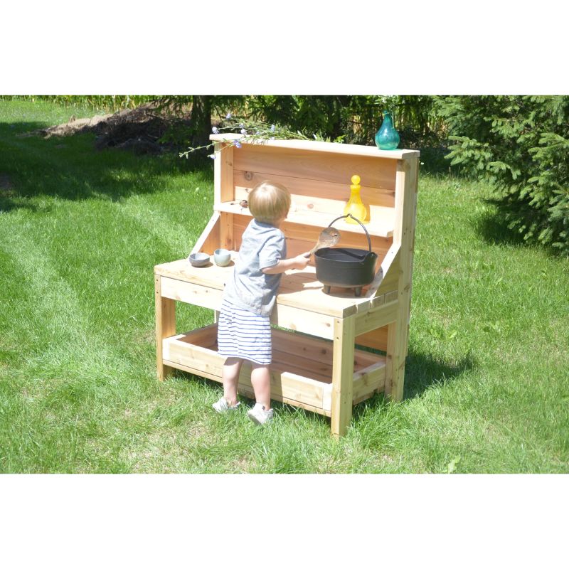 Child playing at the ONP Outdoor Creative Concoction Table, using the cedar outdoor messy play and dramatic role play station in an early years outdoor classroom or backyard setting