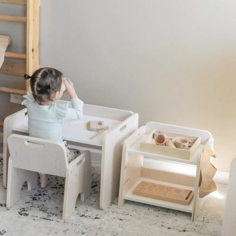Child actively playing at the Sapiens Child Papaya Set Montessori weaning table in a landscape view, showing the adjustable child-height table and chair supporting independent activity made in Vancouver Canada