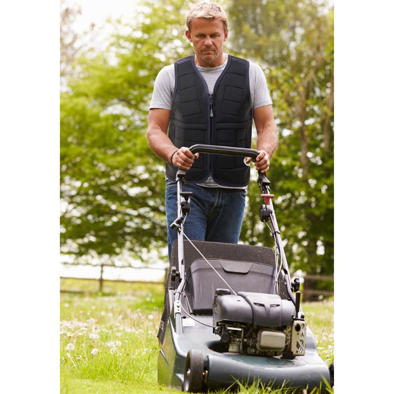 Adult male wearing the Power WearHouse proprioceptive weighted vest while doing yard work, showing versatile everyday use