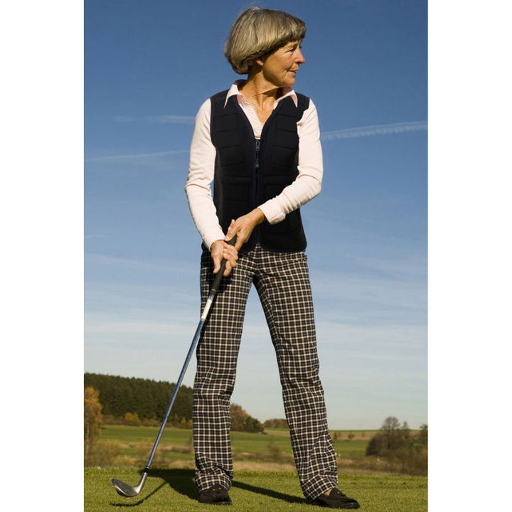Adult female wearing the Power WearHouse weighted vest while playing golf, showing low-profile design for sport and leisure