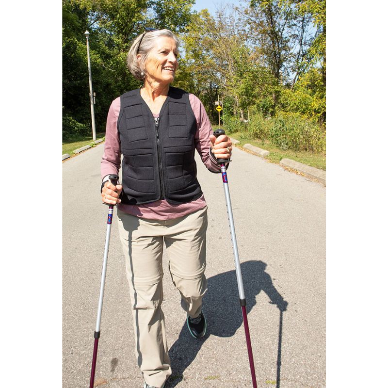 Adult female wearing the Power WearHouse weighted vest while hiking, demonstrating outdoor fitness and bone health use