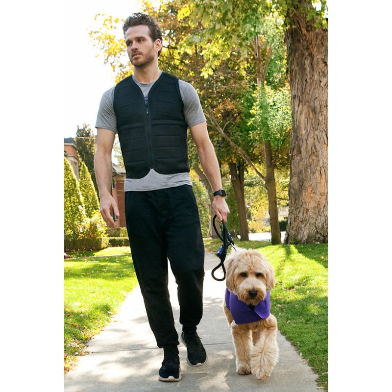 Adult male wearing the Power WearHouse weighted vest outdoors with a dog, demonstrating the discreet everyday fit