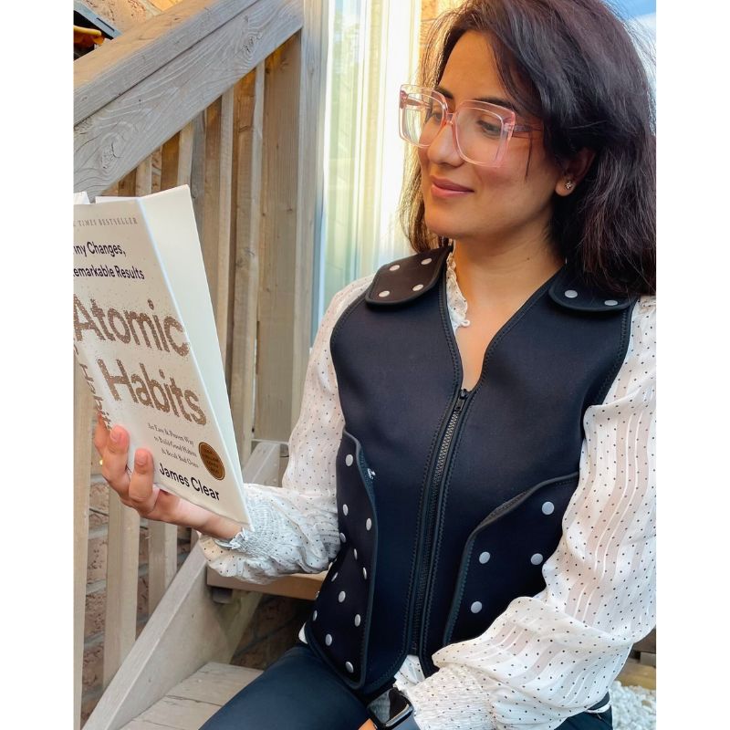 Power WearHouse ProPower Compression Vest for Adults worn by a woman reading, showing the front zip and neoprene fit for deep pressure and sensory regulation