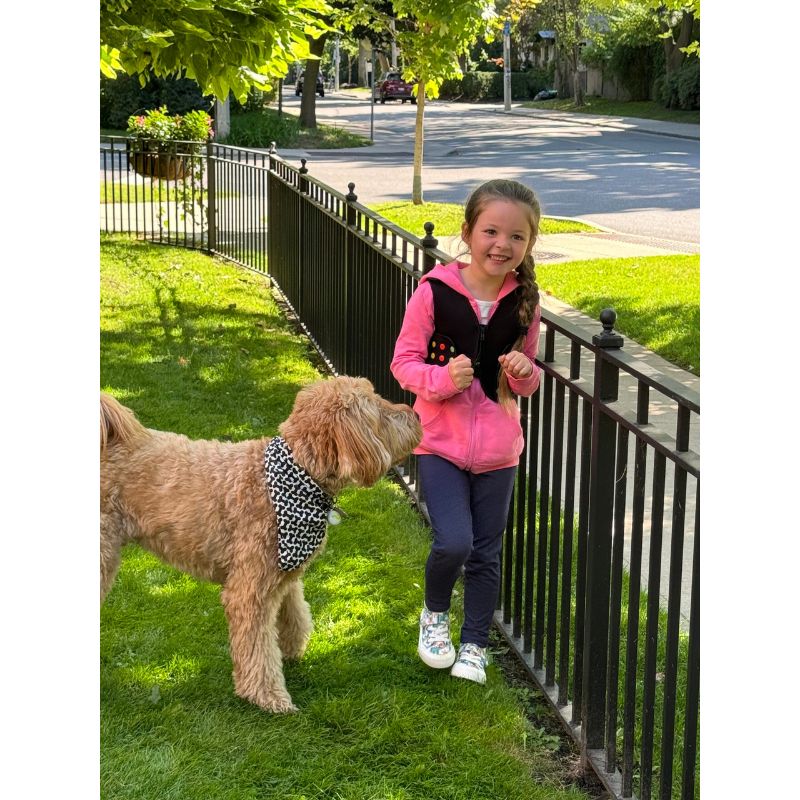 Child wearing Power WearHouse ProPower sensory compression vest outdoors with a pet, showing vest comfort for everyday wear