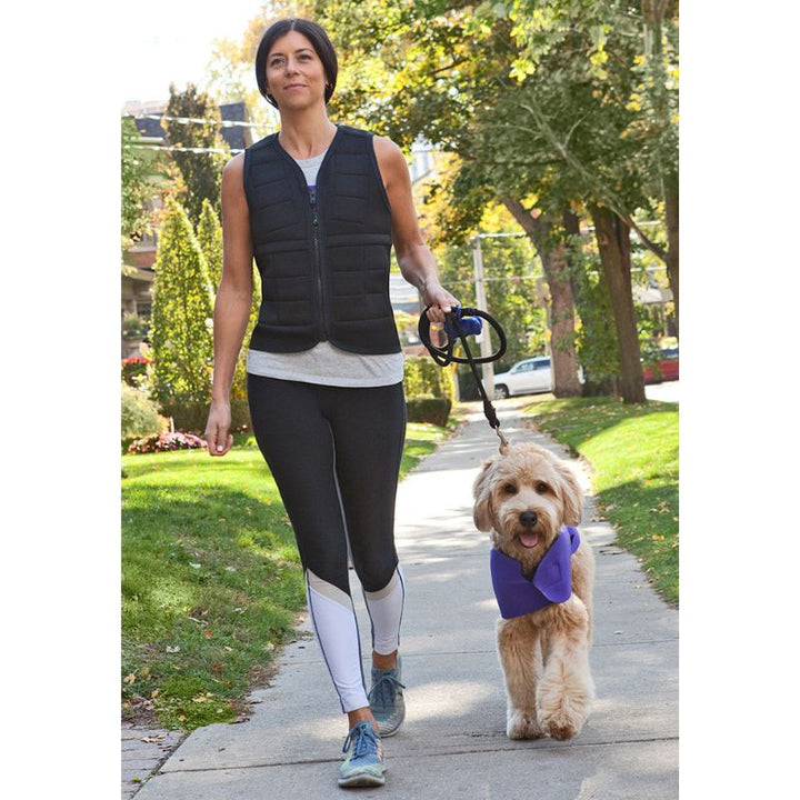Adult female wearing the Power WearHouse weighted vest for deep pressure regulation outdoors with a dog
