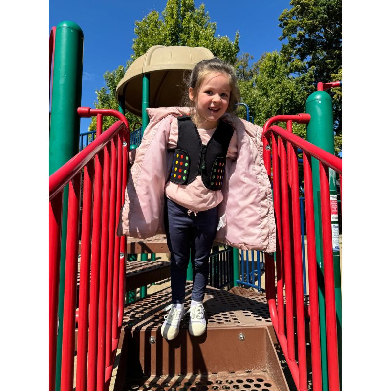 Child wearing Power WearHouse ProPower Compression Vest outdoors at playground, showing sensory vest in everyday use for proprioceptive deep pressure support