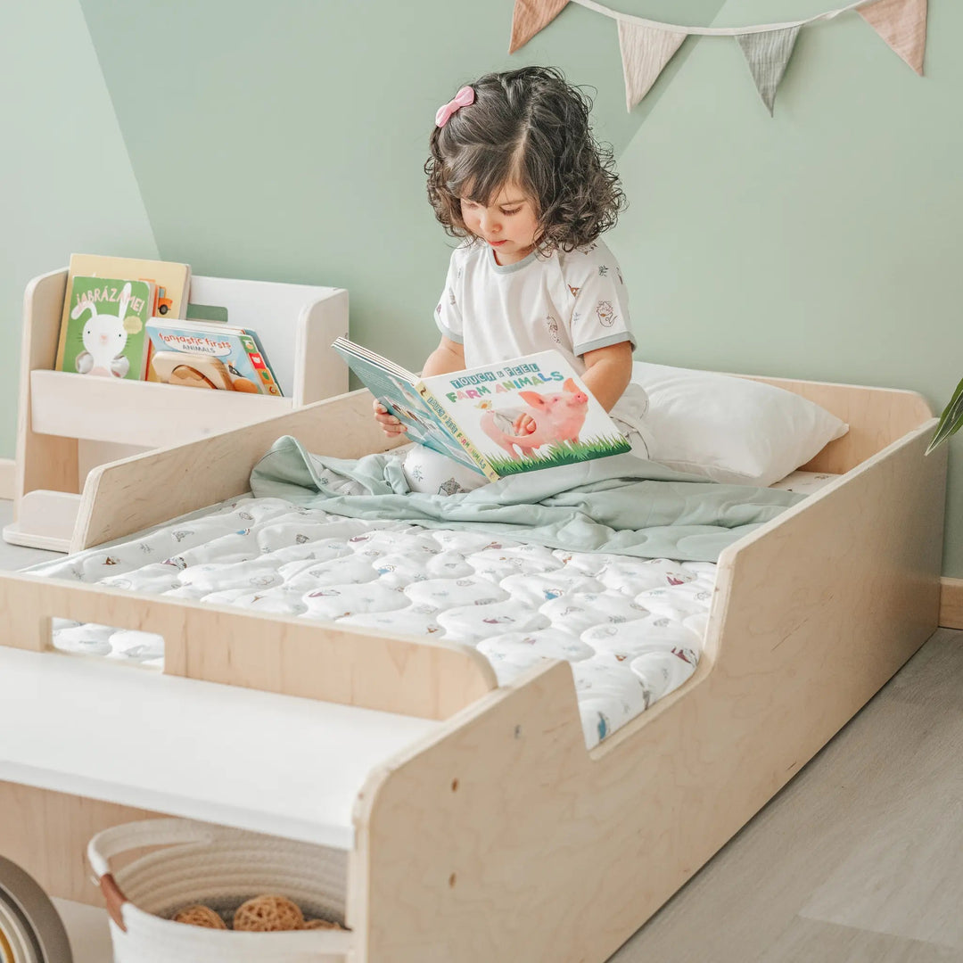 Sapiens Child Apple Montessori floor bed with rails showing the crib-sized mattress positioned in the frame, with protective borders and slatted base visible