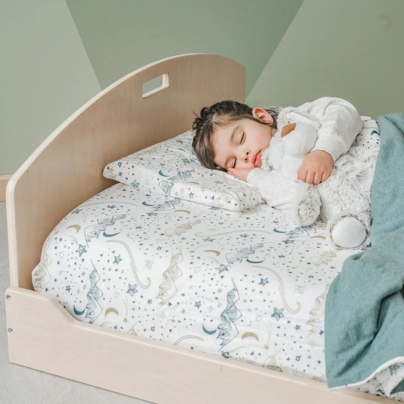 Child sleeping on the Sapiens Child Cherry Twin Montessori floor bed, showing the comfortable low-profile sleeping environment for kids across North America