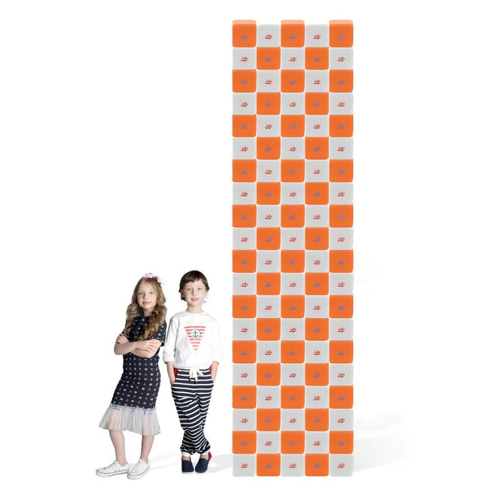 A tower built from JollyHeap Creative Set soft magnetic blocks stacked to full height beside two children, showing the scale of this soft magnetic building block set