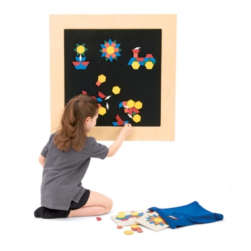 Young girl playing with the Southpaw Puzzle Panel, arranging wooden geometric shapes on the textured hook-and-loop fabric surface of this tactile sensory wall panel
