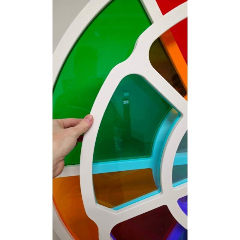 A hand lifting one of the color panels on the LiteZilla ChromaWheel, showing the interactive STEM color wheel's removable panel construction
