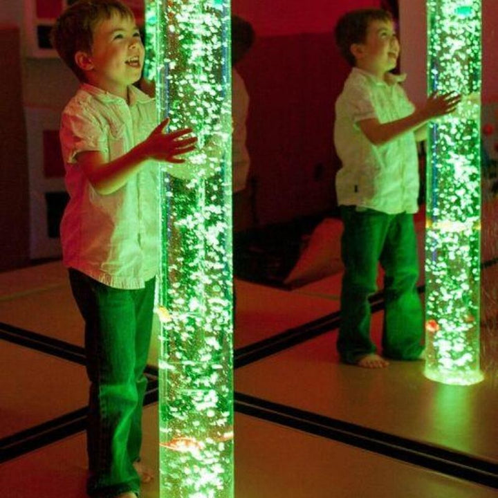 Child engaging with TFH Aquarium Bubble Tube 70-inch in green LED colour showing the sensory bubble column for visual stimulation and chromotherapy in sensory environments