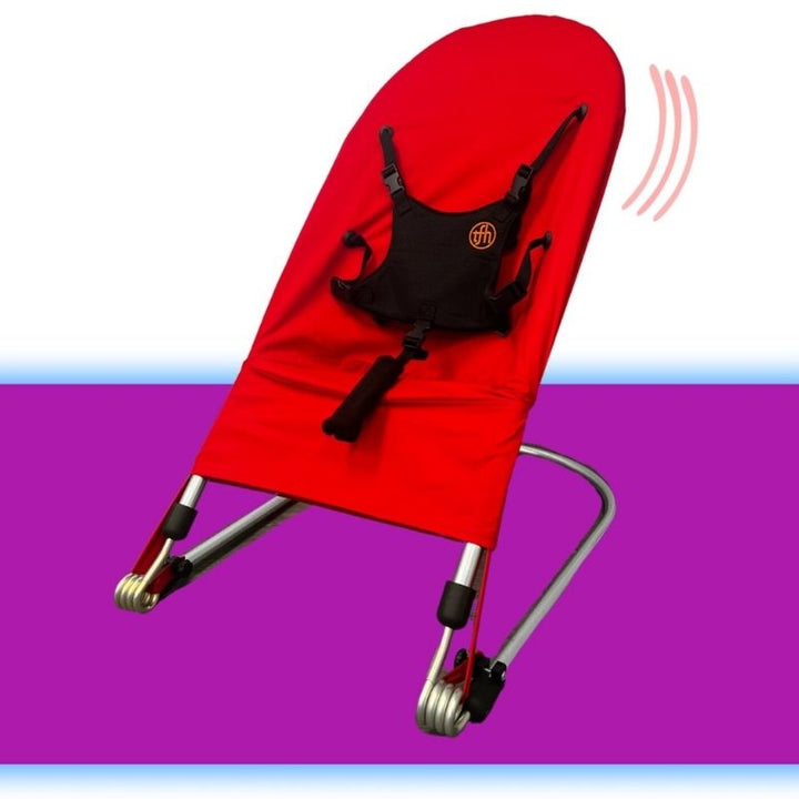 Close front view of the TFH Bouncing Chair large red variant showing the harness and structured sensory seating frame