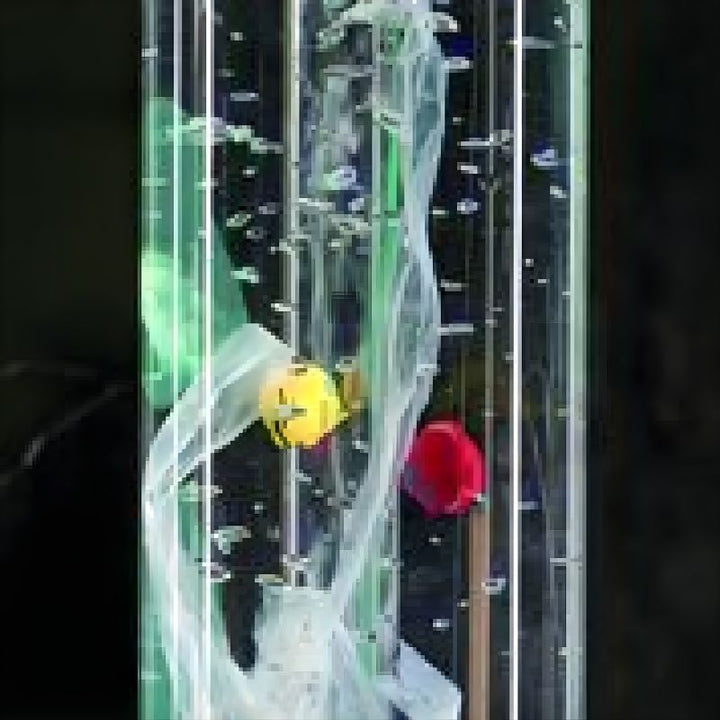Close-up of TFH Standard Bubble Tube Insert cascading beads and acrylic balls against black background showing the multi-colour bead contents
