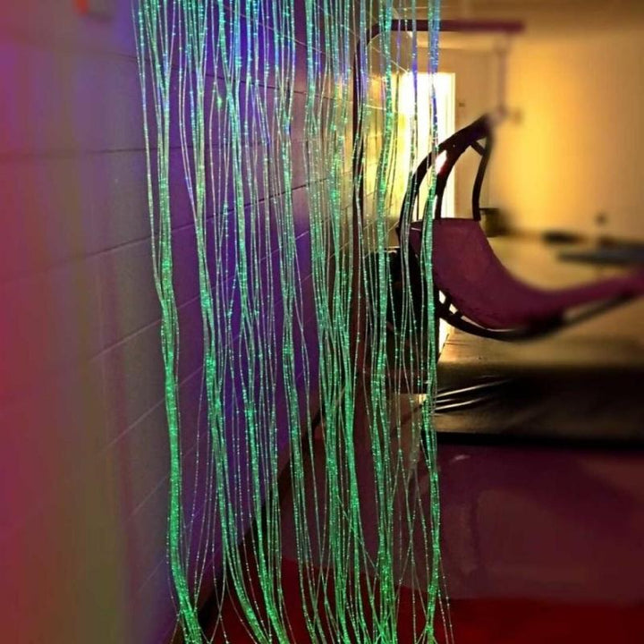 TFH Wall Mounted Fiber Optic Curtain in full landscape view showing the 100-strand curtain mounted on a wall, a calming sensory light for schools, therapy rooms, and home