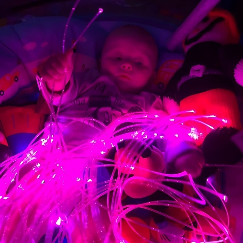 Baby exploring TFH Fibre Optic Tails, demonstrating safe tactile and visual sensory stimulation for infants