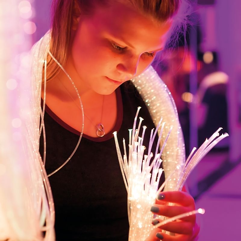 Close-up of TFH Standard Fibre Optic Tails with Sparkle Light Source showing colour-changing sensory lights held by an adult