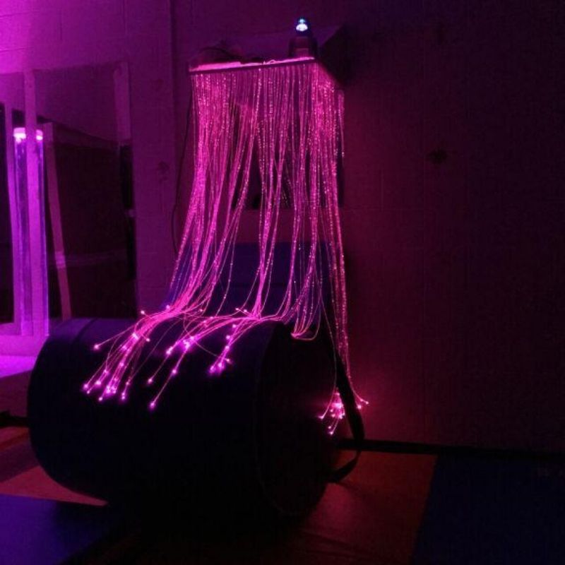 TFH Fibre Optic Waterfall in a landscape sensory room view with tails glowing in soft pink, demonstrating the colour-changing fibre optic light for visual sensory stimulation