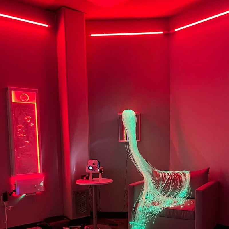 TFH Genie Colour Wash Kit casting a deep red wash across a sensory room wall, showing LED colour light strips in use as visual sensory room equipment