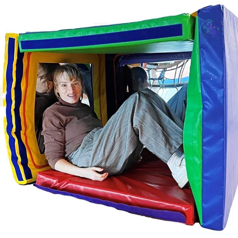Adult inside the TFH Giant Folding Mirror Den cube configuration exploring reflective mirror panels, showing the den is suitable for all ages and a range of users