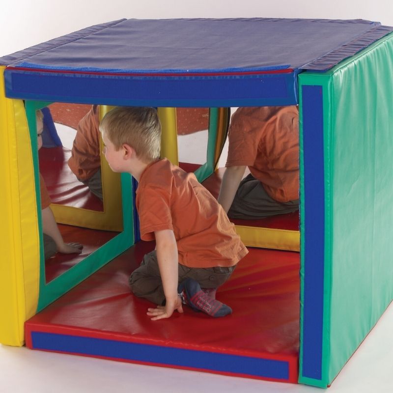 Boy sitting beside the TFH Giant Folding Mirror Den exploring the exterior foam panels and colourful framed mirrors for sensory and visual play