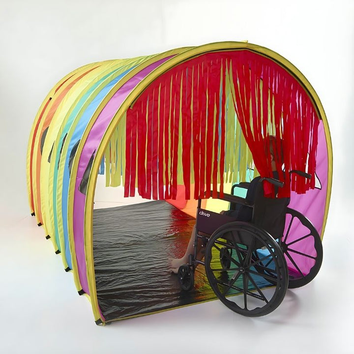Child inside the TFH Giant Tickle Me Tunnel surrounded by colourful Velcro streamers delivering tactile sensory input