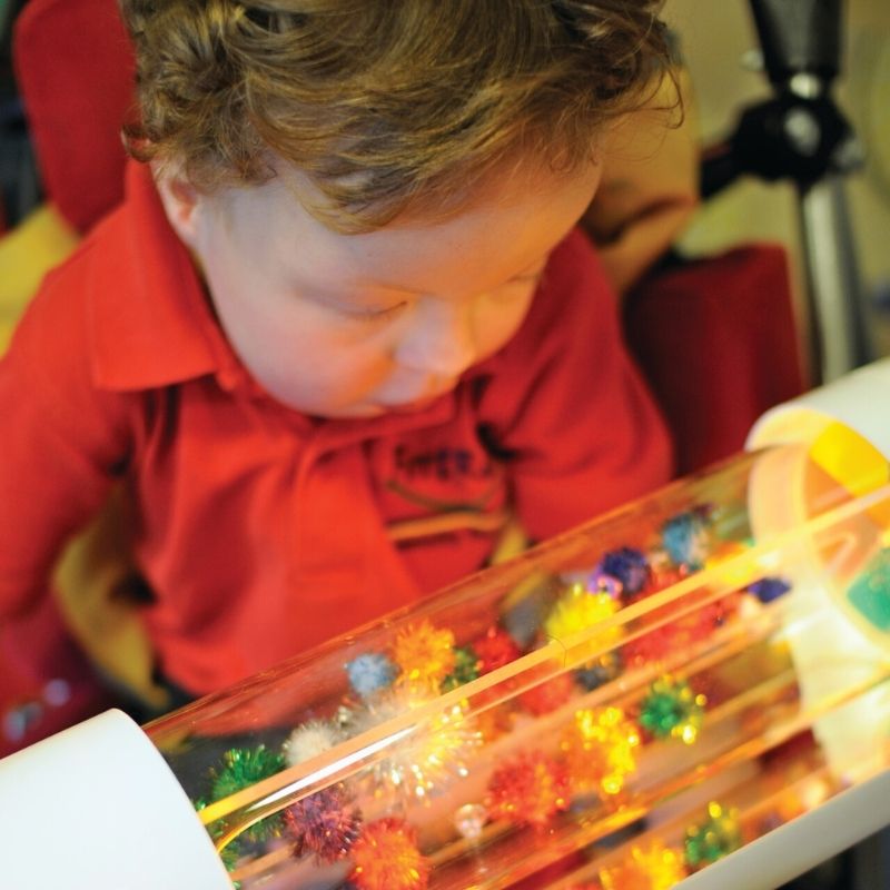TFH Glitter & Lights Roll Adapted Reward illuminated with soft internal lighting, showing the motorised rotating drum for switch-adapted sensory and cause-and-effect learning