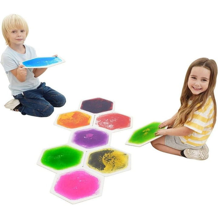 Children engaged in active play on the TFH Hexagon Liquid Floor Tiles 9 Set, showing gross motor movement and the colour-shifting liquid response to stepping and jumping