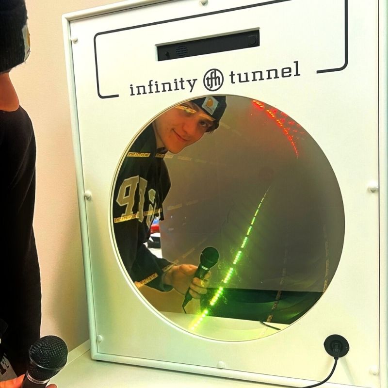 TFH Interactive Infinity Tunnel and Microphone with a boy actively playing and seeing his reflection in the optical illusion sensory wall panel, demonstrating the visual depth effect