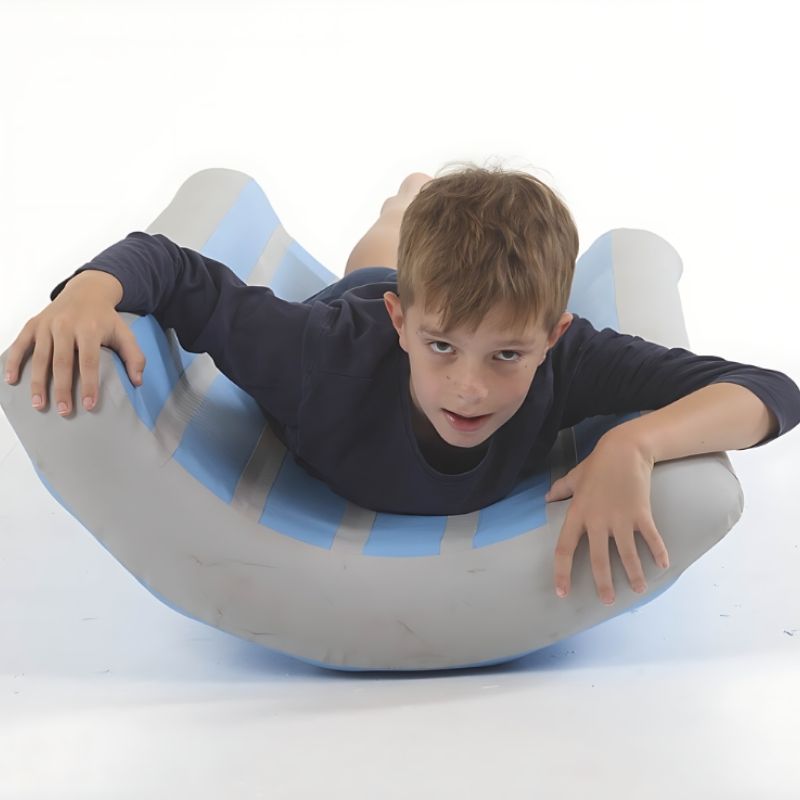 Boy balancing and rocking in the TFH Inflatable Body Rocker, a vestibular sensory toy for children