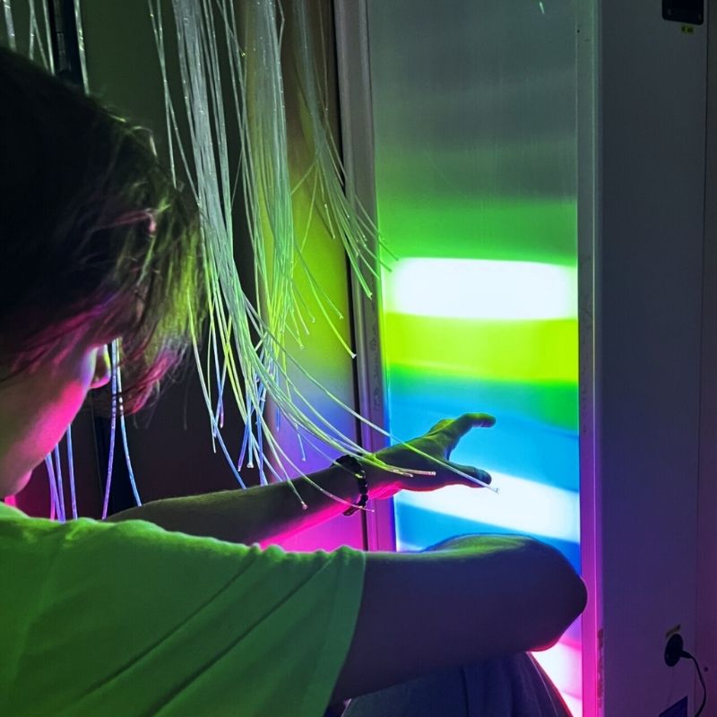 TFH Sound Responsive Ladder Light Panel with a boy actively playing in green-toned lighting, demonstrating the colour-changing rungs responding to voice for speech therapy and sensory room use