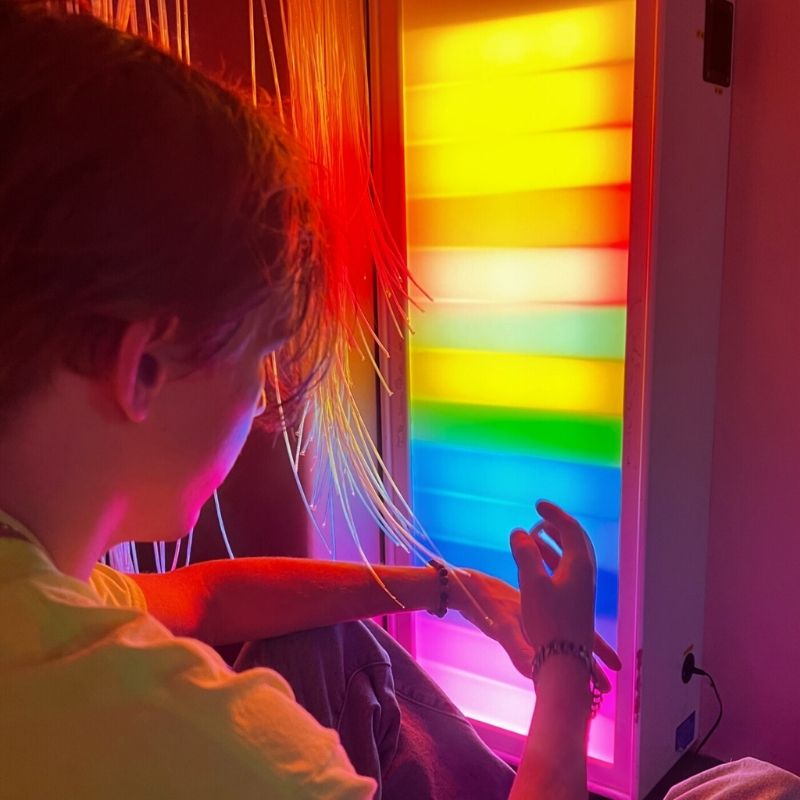 TFH Sound Responsive Ladder Light Panel with a boy actively engaging with the 15-rung colour LED display, showing the ascending sound-activated visual biofeedback in use during sensory play