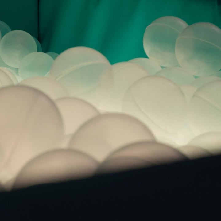 Close-up of TFH Large Light-Up Ball Pit showing translucent sensory balls in cool white-blue LED light