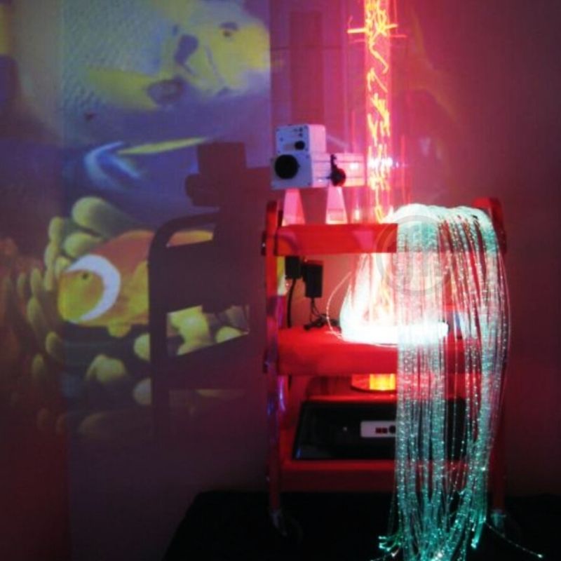 TFH Little Red Sensory Cart Deluxe Hurricane Waterless in a clinical or therapy room setting showing the portable waterless sensory station projecting onto a wall with fibre optic tails in use