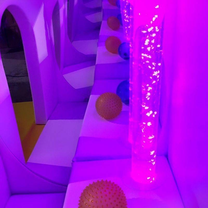 TFH Deluxe Portable Sensory Den with bubble tube glowing in purple light, demonstrating the portable calm corner enclosure with colour-changing sensory tube for self-regulation in schools and therapy settings