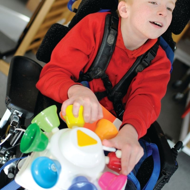 TFH Rainbow Carousel Bells Adapted Reward in a sensory room or therapy setting, used as an auditory cause-and-effect sensory reward for switch access and musical exploration
