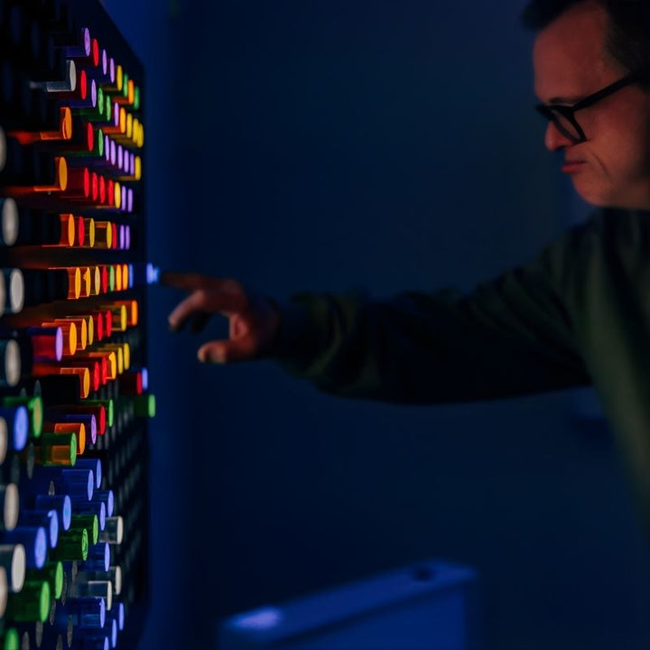TFH Rod Wall Activity Panel with an adult man engaging from the side, showing the full-height wall-mounted 28-inch illuminated rod panel for all ages and abilities