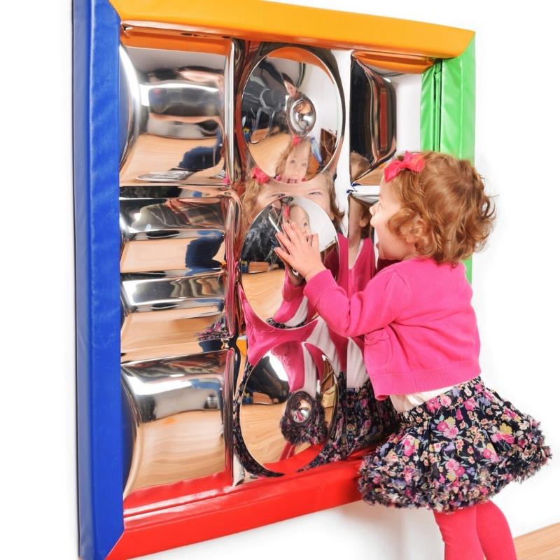 Child interacting with the TFH Sensory Mirror With Padded Frame, showing the nine distortion surfaces and soft colourful padded frame in an active sensory room setting