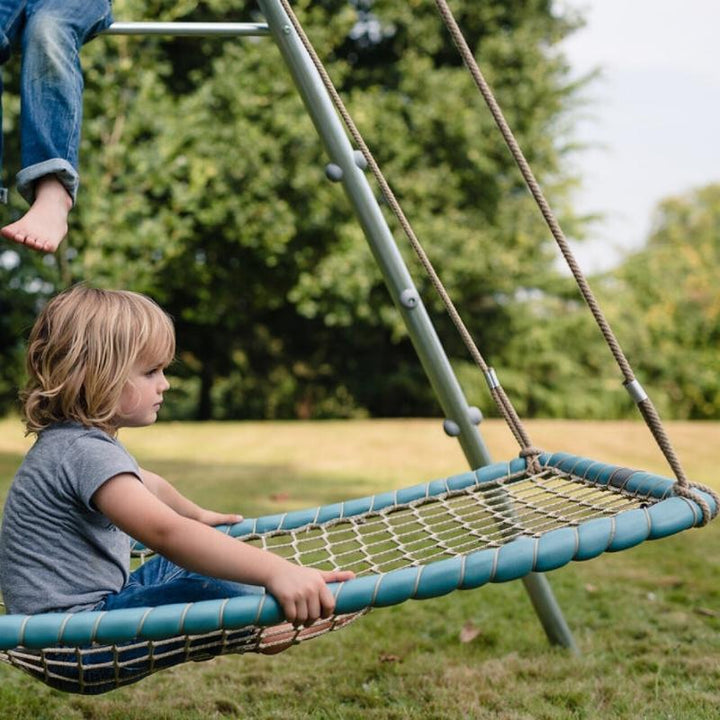 Child playing in the TFH Sky Cruiser Net Swing, a hammock-style sensory swing for vestibular input and sensory integration therapy