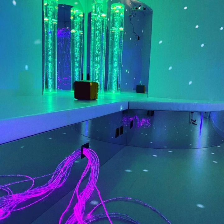 TFH Square Podium Base in aruba blue light showing the padded mirrored sensory room podium with bubble tube for occupational therapy clinics, schools and sensory rooms across North America