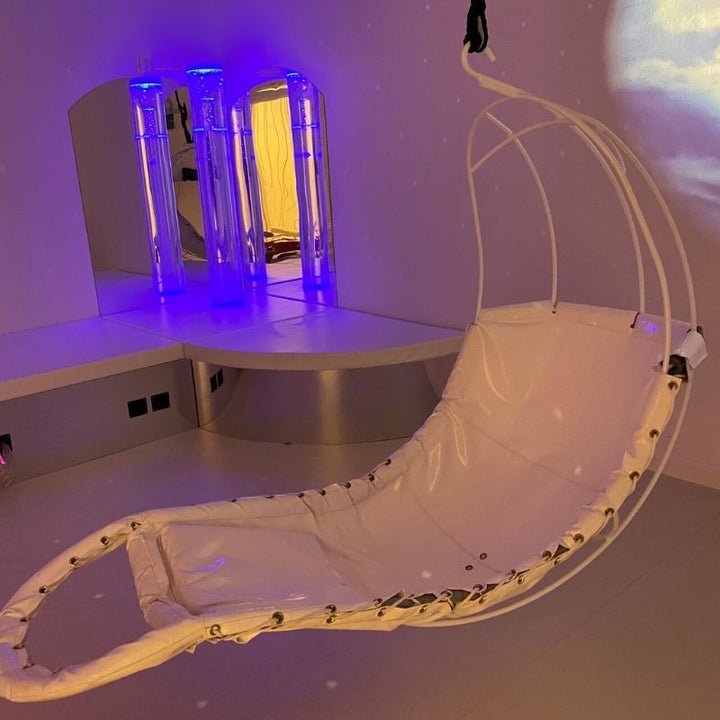 TFH Swaying Banana Leaf Chair in an indoor setting showing the suspended vestibular sensory swing providing full-body support for calm and regulation