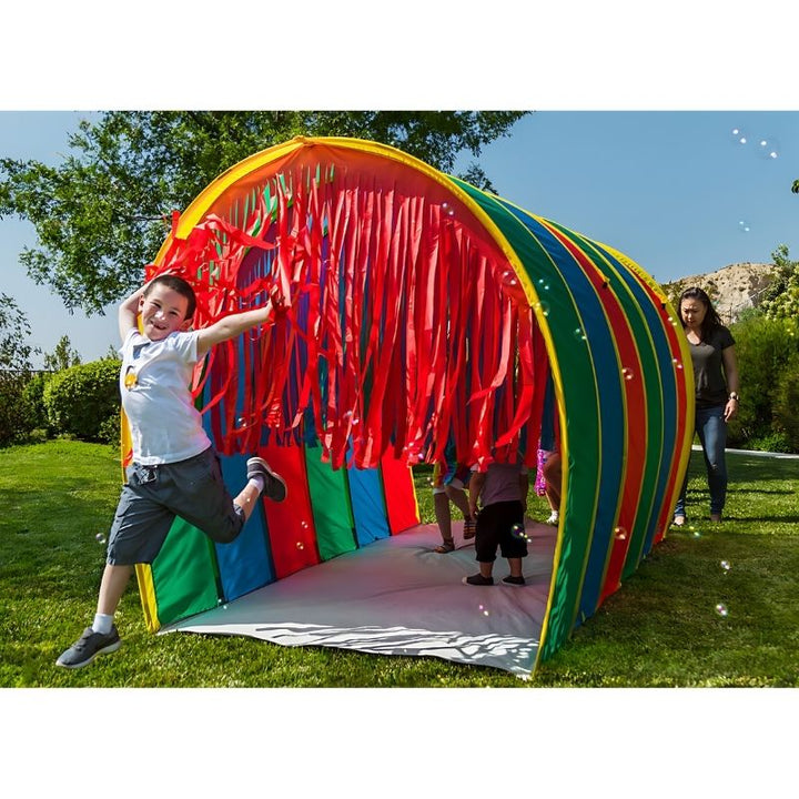 Child hopping and moving through the TFH Giant Tickle Me Tunnel during active motor play and sensory exploration