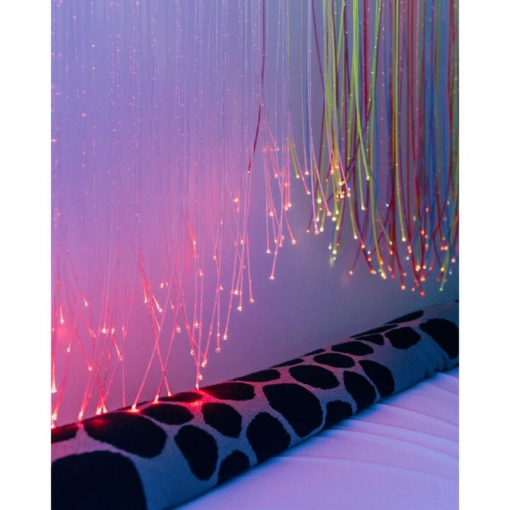 TFH UV Fibre Optic Tails hanging as a sensory room light display, showing the full 80-inch strand length glowing under UV light