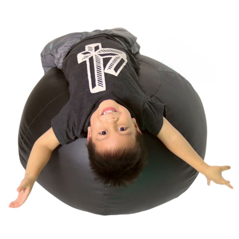 TFH Vibroacoustic Puffy Cloud seen from above with a child actively using the bean-filled sensory bean bag, showing the full-body contact surface for vibroacoustic therapy at home and in sensory rooms
