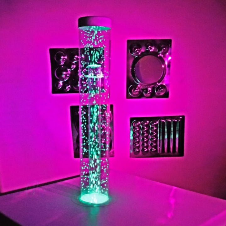 TFH Interactive Waterless Hurricane Tube in a sensory room landscape view glowing in pink, showing the colour-changing snow bead waterless bubble column as part of a multi-sensory space