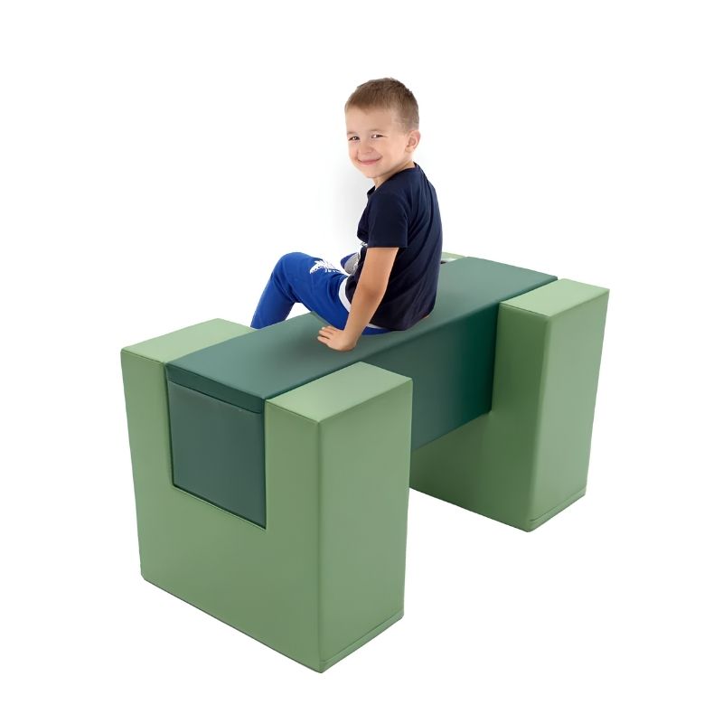 Child sitting on the IGLU Balance Bridge foam balance beam in green during active play
