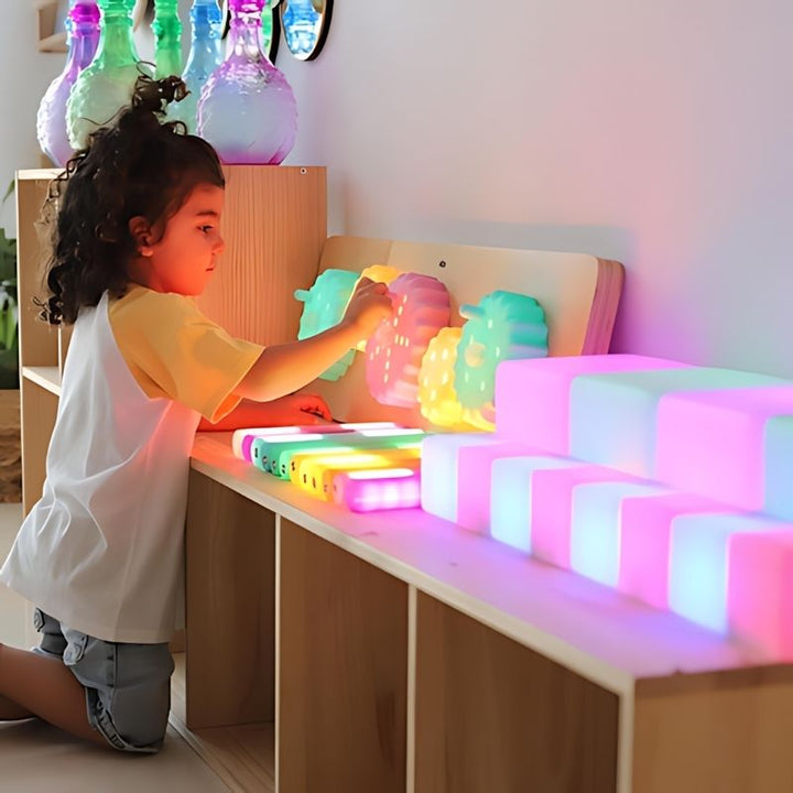 TTS Light Up Cog Board during active child play, showing the wooden sensory fine motor resource in a nursery or home setting