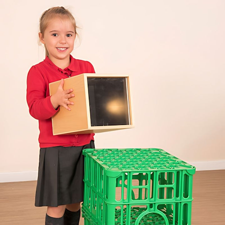 Young child independently holding and positioning the TTS Early Years Projector, demonstrating its lightweight, wireless design for child-led STEAM and sensory exploration in classrooms